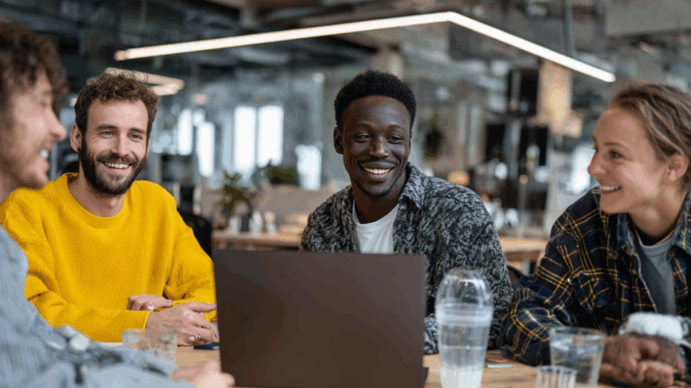 Des bénévoles réunis autour d’une table consultent un ordinateur portable pour gérer la comptabilité d’une association en toute transparence.